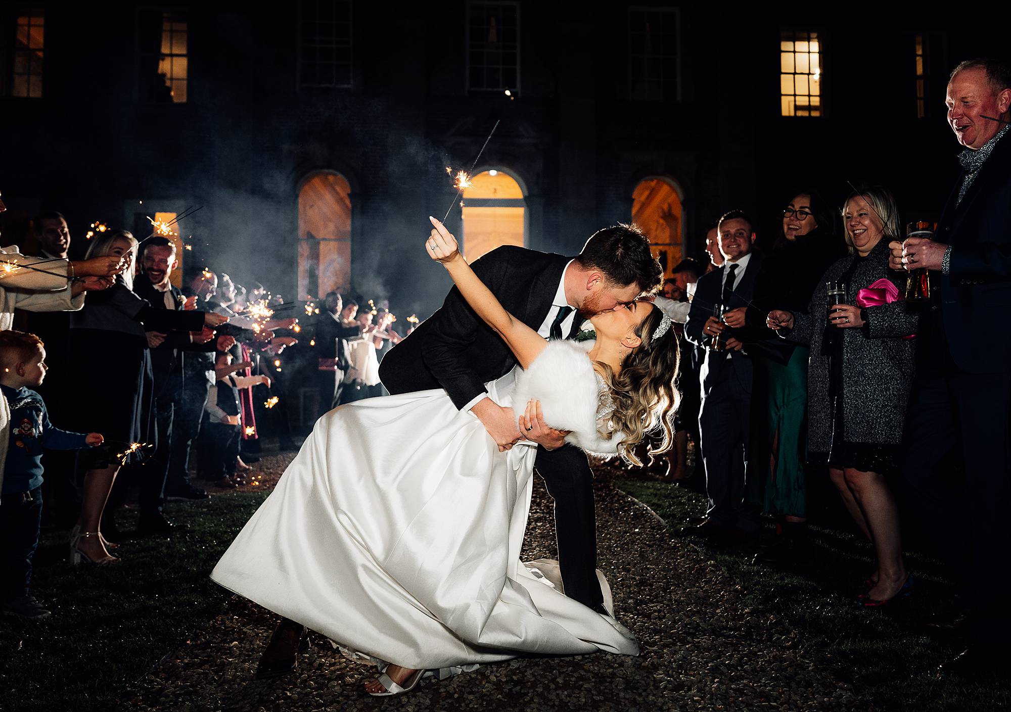 Groom dips bride during a sparkler exit at Crowcombe Court
