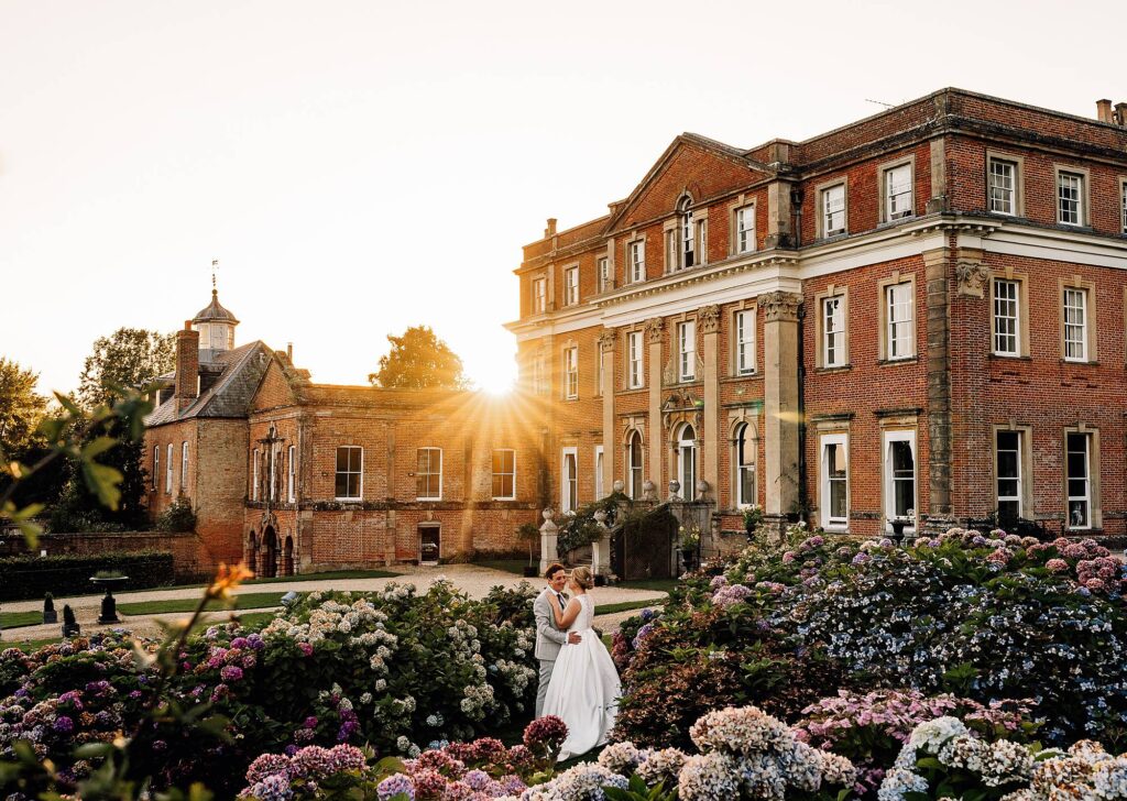 Beautiful golden hour portrait of couple kissing with Crowcombe Court in the background
