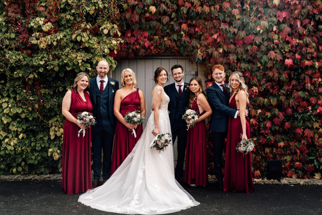 Bride and groom along with wedding patty standing in front of autumn flowers at the great barn, Devon.
Paul aston photography
Somerset wedding photographer 