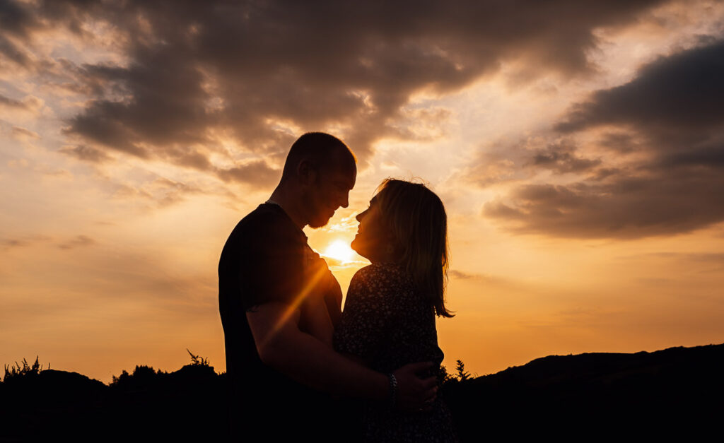 Couple embraced on the quantock hills of somerset at golden hour