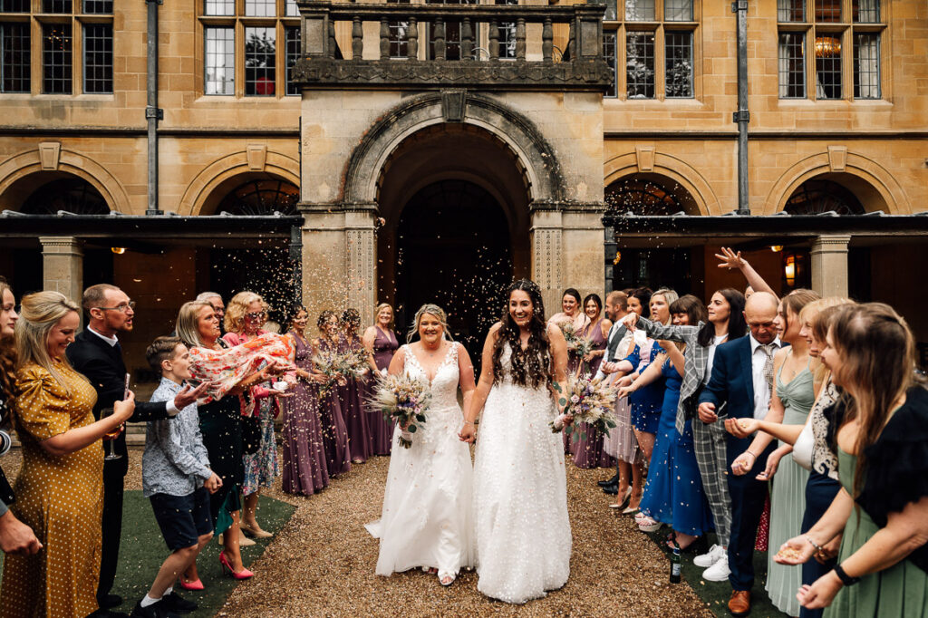 Bride and Bride walking through Confetti line at coombe lodge in somerset