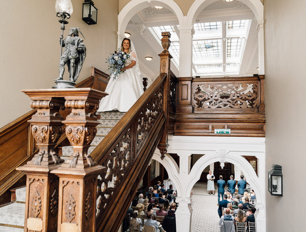 Bride abou to walk down the stairs into the ceremony room at Clevedon Hall