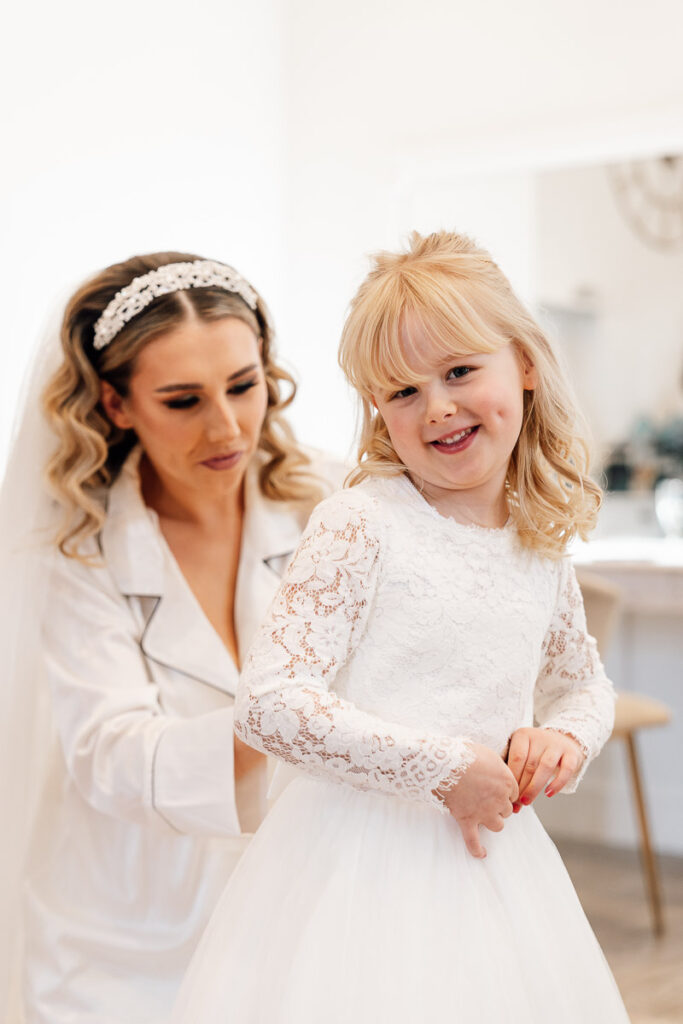 Bride getting her daughter into her dress for the wedding at crowcombe court