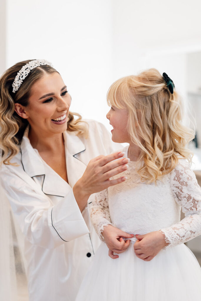Bride getting her daughter into her dress for the wedding at crowcombe court
