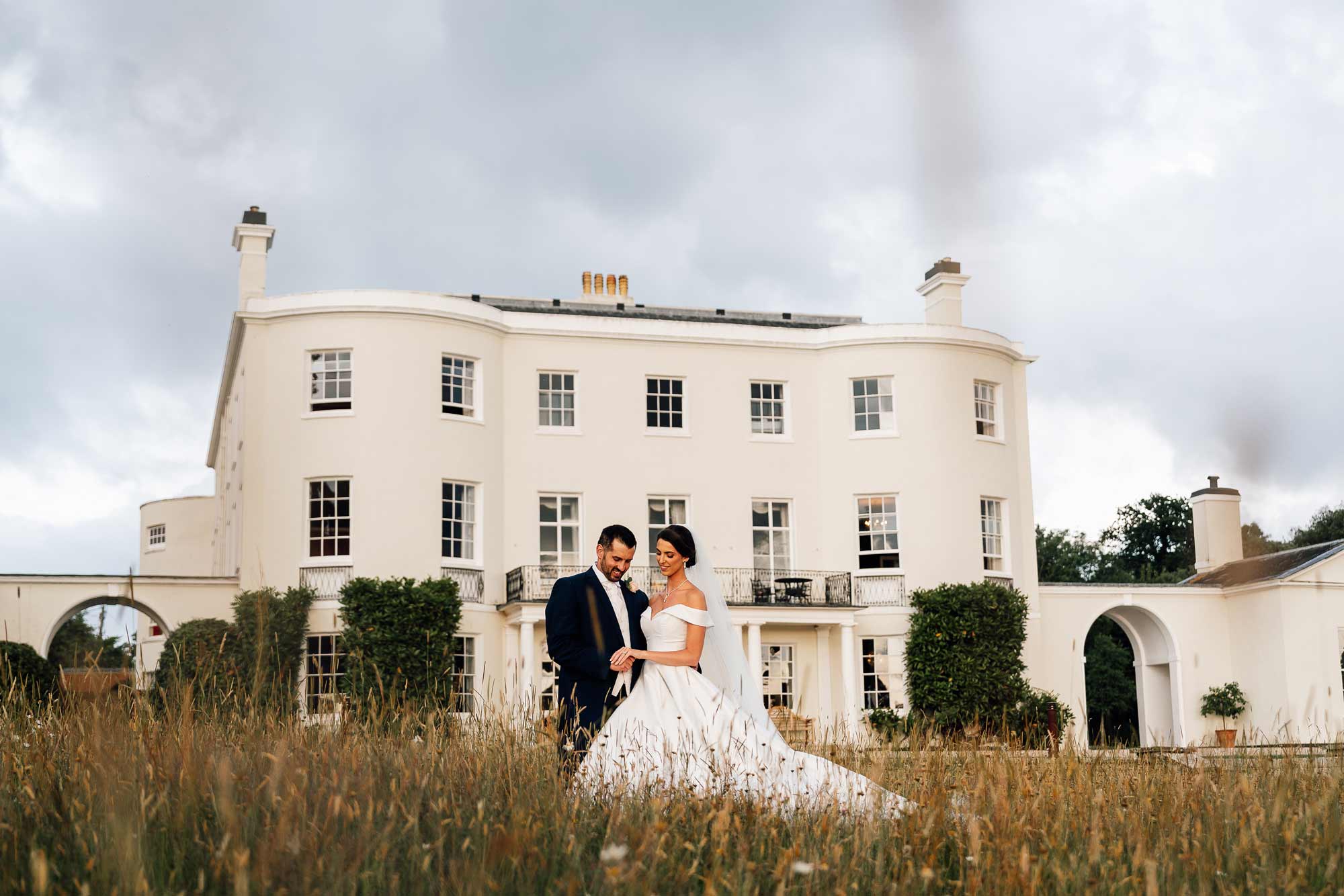 Bride and Groom standing in front of rockbeare manor having a lovely embraced moment