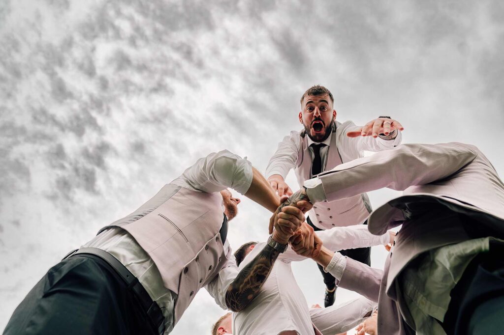 Groom being chucked up in the air by all his groomsmen at crowcombe court venue.