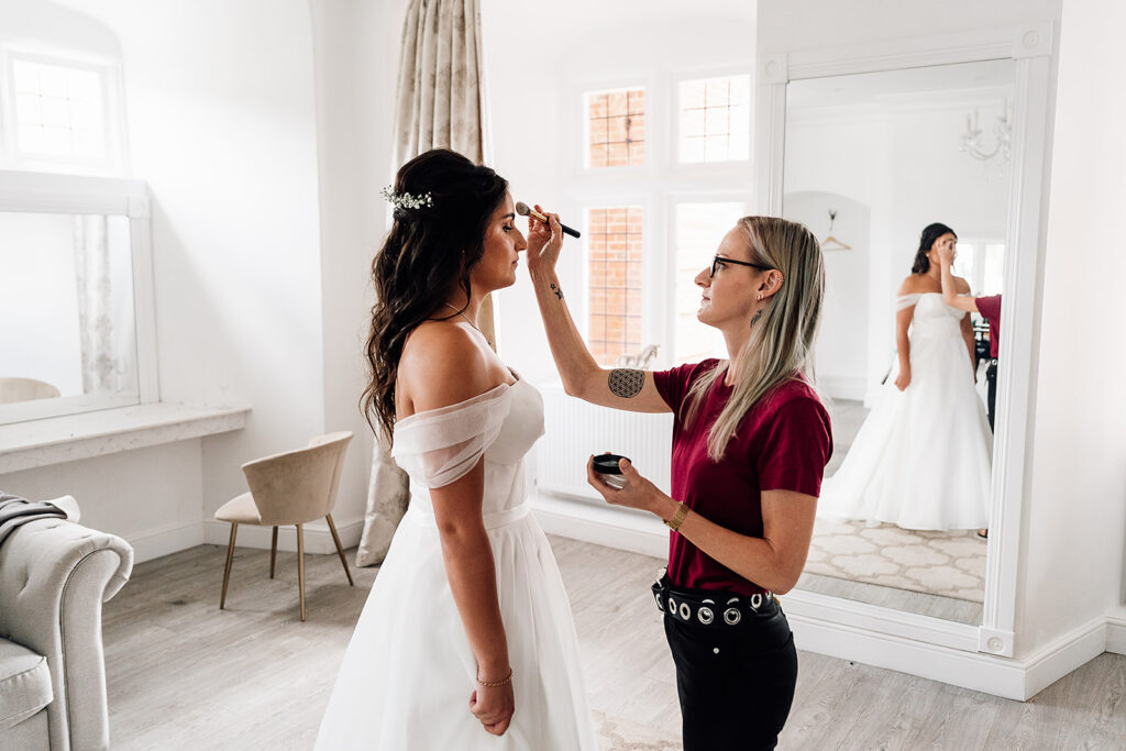 Make up Artist fixing the final details of the brides makeup at Crowcombe court wedding venue


