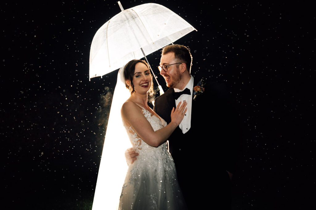 Somerset wedding photographer couple standing in the rain outside crowcombe court wedding venue